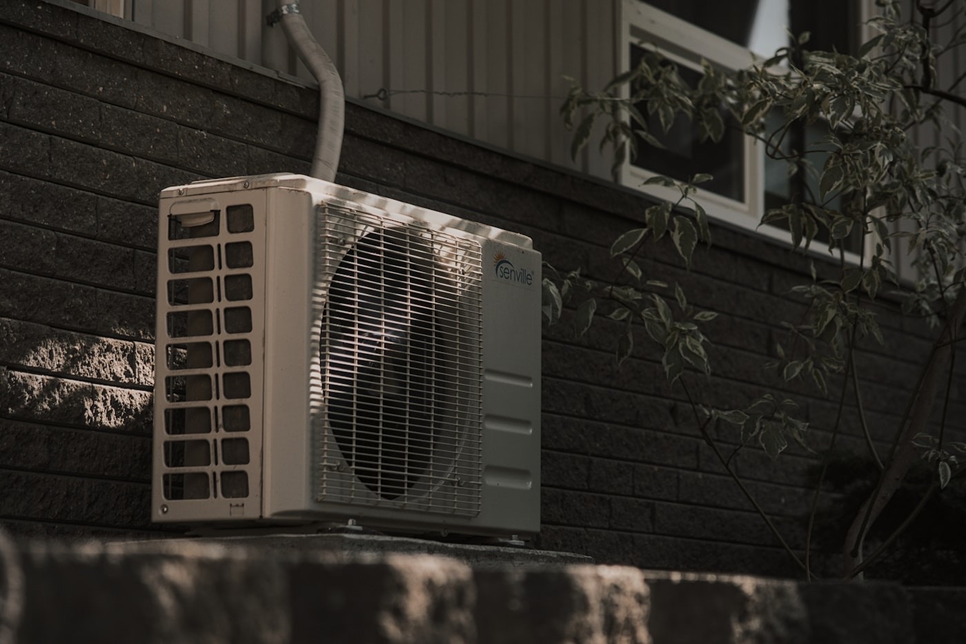 Residential air conditioning condenser unit installed outside a home